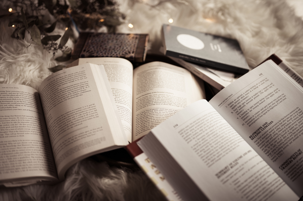 A Bunch of Open Books on a Fluffy Blanket 